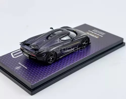 Diecast sports car model in dark gray carbon-fiber style on purple display base