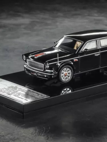 Black 1:64 diecast model car, front three-quarter view on display base