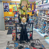 Standing collectible figure with face mask and black outfit, arms posed forward