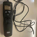 Black wireless DSLR shutter remote with LCD screen and control buttons, tethered cable