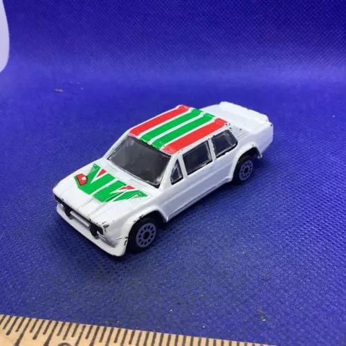 Diecast model car, white with green and red racing stripes, front three-quarter view
