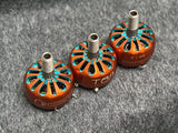 Orange brushless drone motors with teal fan fins and mounting shafts, set of three