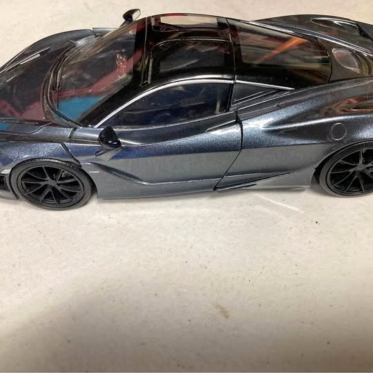 McLaren 720s diecast model car, dark blue side view with black roof and wheels
