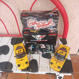 Racing diecast car in yellow with two open-wheel models and retail box