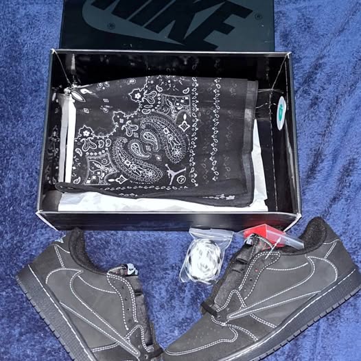 Black bandana with white paisley pattern and gray-stitched black sneakers in box