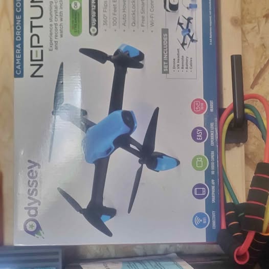 Boxed blue quadcopter drone with three visible propellers