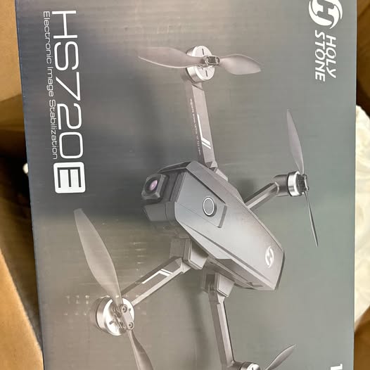 Gray foldable quadcopter drone with four rotors on retail box