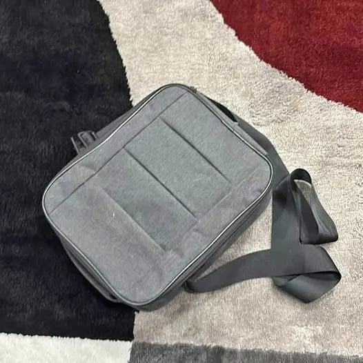 Gray sling bag with front zipper pocket and adjustable strap