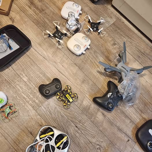 Quadcopter drones with remote controller and small accessories on a floor