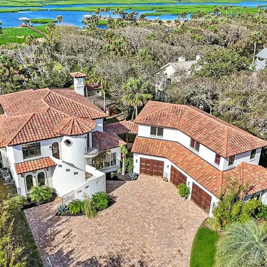 Aerial view of a house with red tile roof and driveway