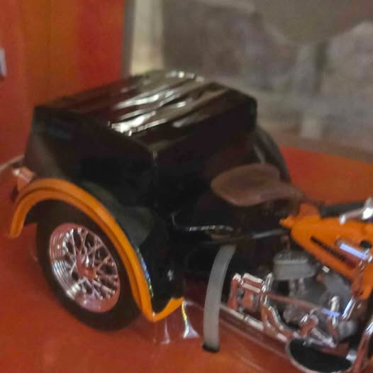 Harley-Davidson diecast motorcycle model, black and orange with chrome front wheel