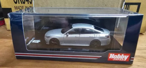 Tomica die-cast car model in retail box, silver gray side view