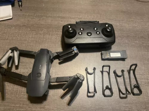 Foldable DJI drone with controller and camera module, showing landing legs