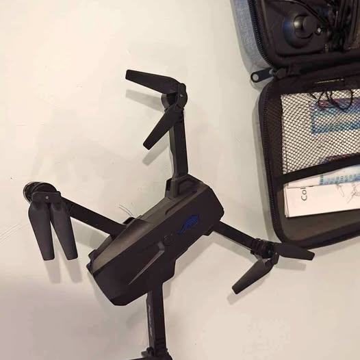 Black quadcopter drone with four propellers and foldable arms