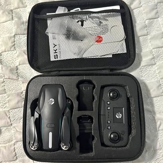 Drone with camera in black hard case, controller and extra parts visible