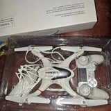 White quadcopter drone with prop guards in clear plastic retail box tray