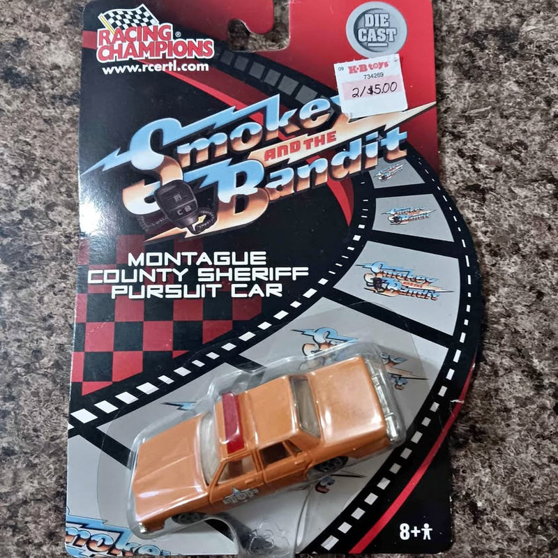 Orange diecast race car in blister pack on branded card