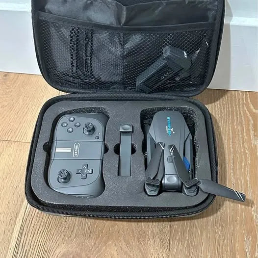 Open drone carrying case with controller, battery, and folded quadcopter