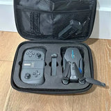 Open drone carrying case with controller, battery, and folded quadcopter