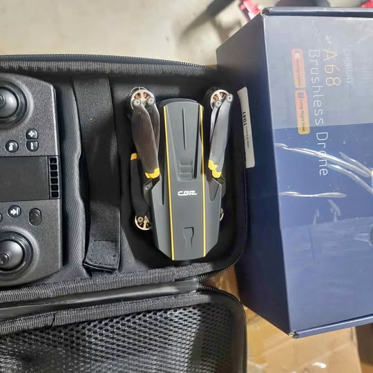 Folded camera drone in case, gray body with yellow accents