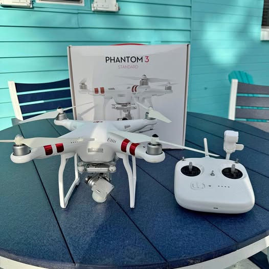 White quadcopter drone with red stripes and white remote controller with two antennas