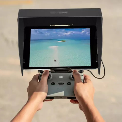 Tablet sun hood monitor with bright display and drone controller, hands adjusting