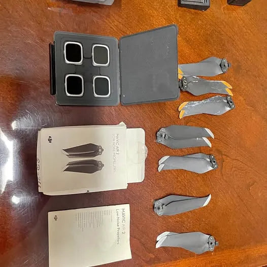Drone battery charger and six gray propellers with blades