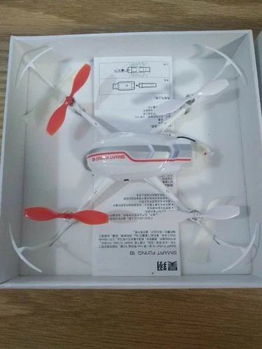 White quadcopter drone with red stripe, four propellers in retail box
