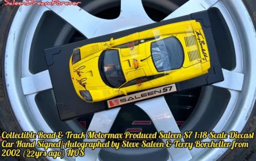 Yellow diecast race car model with black base, viewed from above