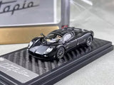 Black diecast sports coupe model car with chrome wheels on display base.