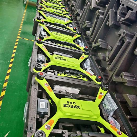 Neon green foldable quadcopter drone in a gray protective foam tray
