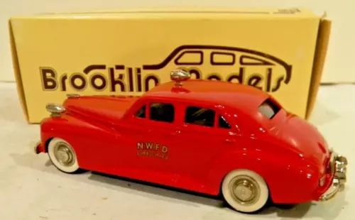 Red vintage diecast sedan model car with black windows, whitewall tires, NWFD badge.