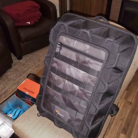 Gray padded drone storage case with zip front pockets and adjustable shoulder straps