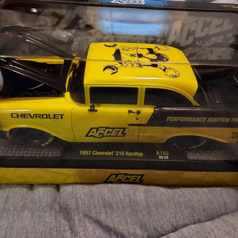 Yellow and black diecast 1957 Chevy 210 car model with Accel decals, front view