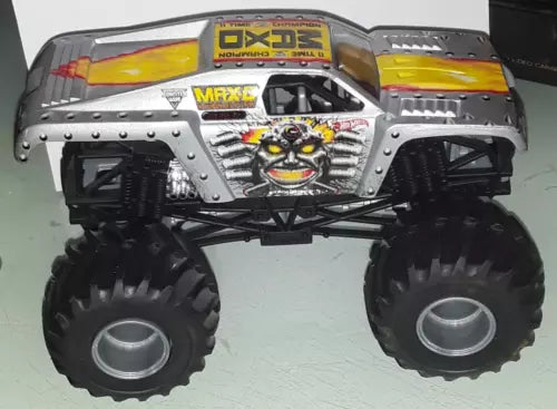 Silver/gray diecast monster truck with Monster Jam-style graphics and oversized wheels