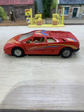 Red diecast pull-back action toy car, side view with yellow and blue racing stripes.