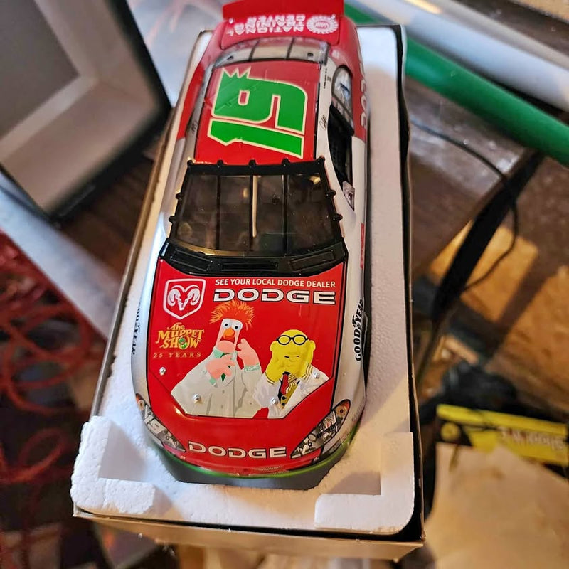 Red diecast race car with Dodge decals and green front logo, in display box