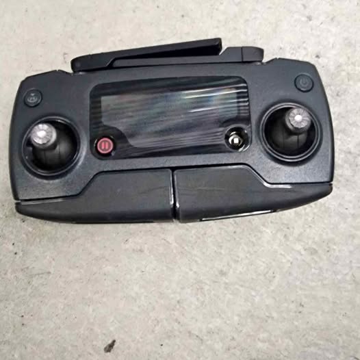 Black drone remote controller with dual joysticks and built-in screen