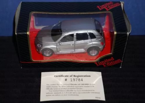 Silver diecast PT Cruiser model car with red interior and registration certificate.