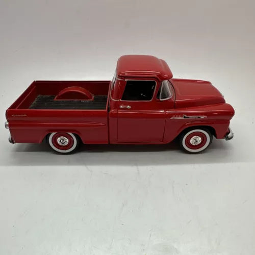 Red 1958 Chevy Apache Fleetside diecast pickup truck, side view with whitewall wheels.