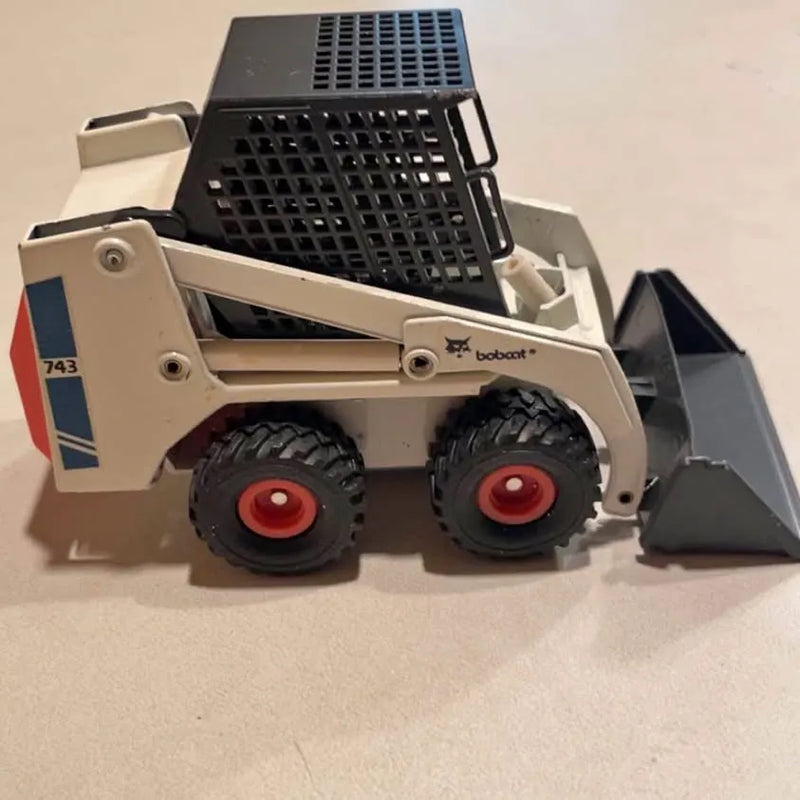 1:19 scale diecast skid-steer loader with front bucket and two treaded wheels