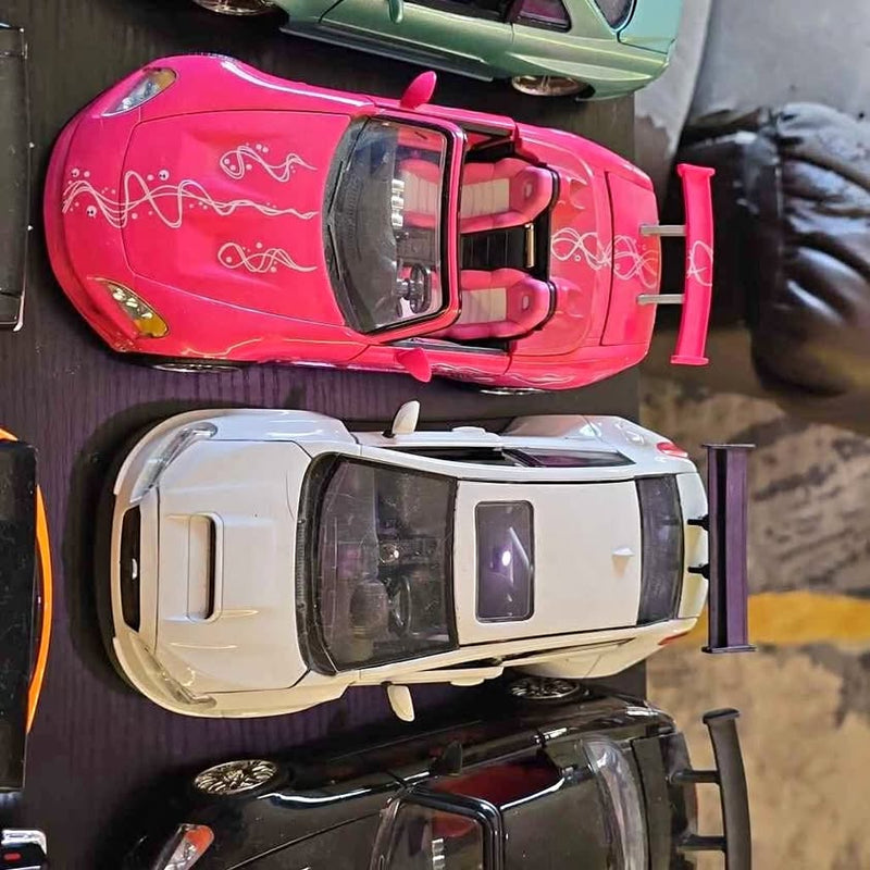Pink diecast toy car model with white side stripes, front view, chrome wheels