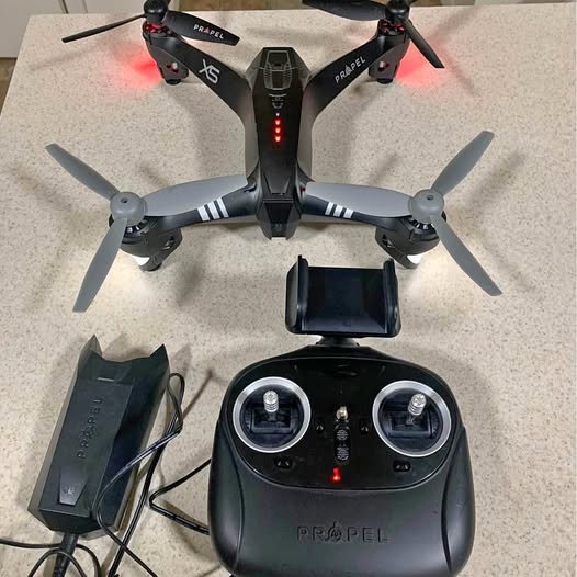 Outdoor quadcopter drone with HD camera, black body, four propellers, and controller