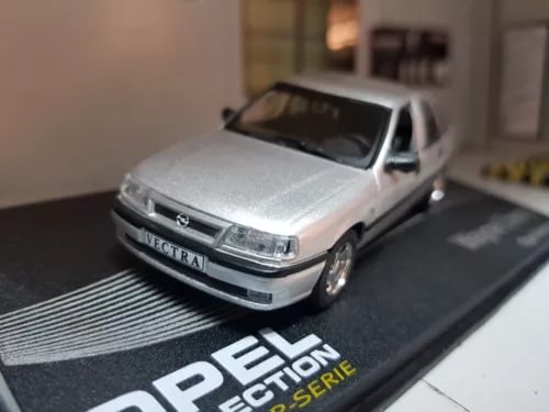 Silver sedan diecast model car with front view, on display base