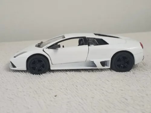 White diecast model sports car toy with black wheels, side view