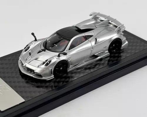 Silver 1:64 racing diecast model car with black accents on display base