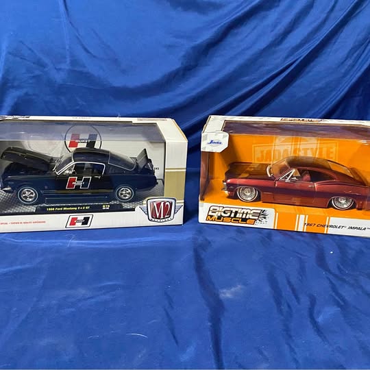Boxed diecast cars: black and orange models in clear-front display boxes
