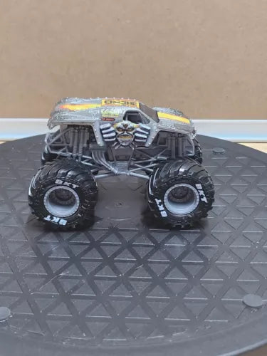 1:64 diecast monster truck, gray with dark tires and detailed engine grille, front view