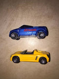 Diecast toy car pair: blue and yellow roadsters with wheels and side decals