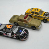 Collectible diecast cars set with black race car, yellow truck, and tan car